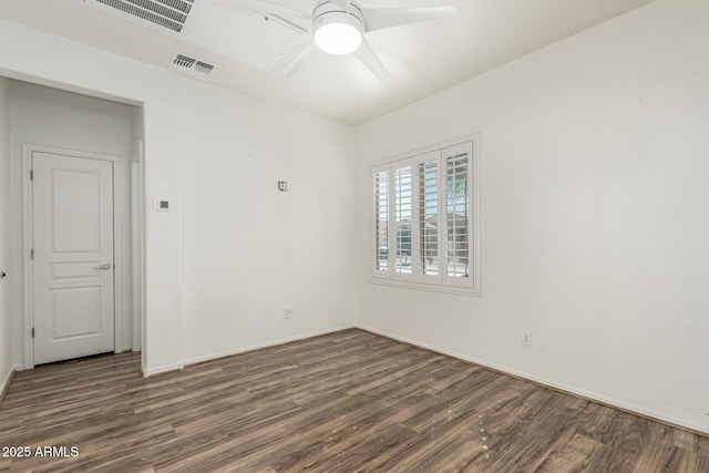 spare room with a ceiling fan, visible vents, and wood finished floors