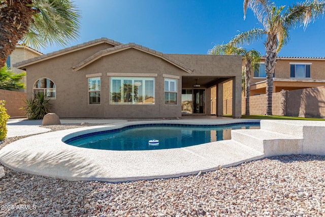 back of property with a patio area, fence, a fenced in pool, and stucco siding