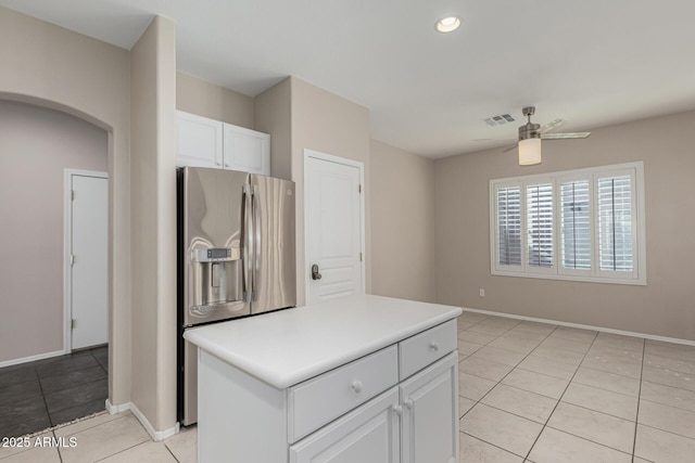 kitchen featuring arched walkways, white cabinetry, visible vents, a ceiling fan, and stainless steel refrigerator with ice dispenser