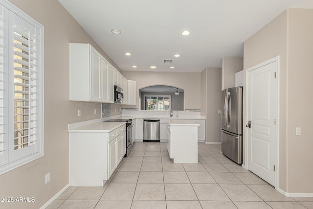 kitchen featuring stainless steel appliances, white cabinets, light countertops, and a sink