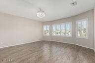 spare room featuring baseboards and wood finished floors