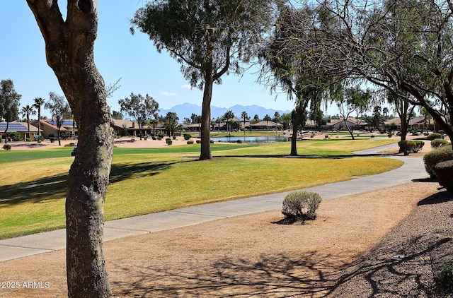 surrounding community with a lawn and a water and mountain view