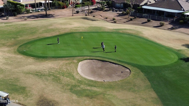 view of community with golf course view and fence