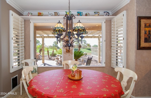 dining space with a notable chandelier, a healthy amount of sunlight, and ornamental molding