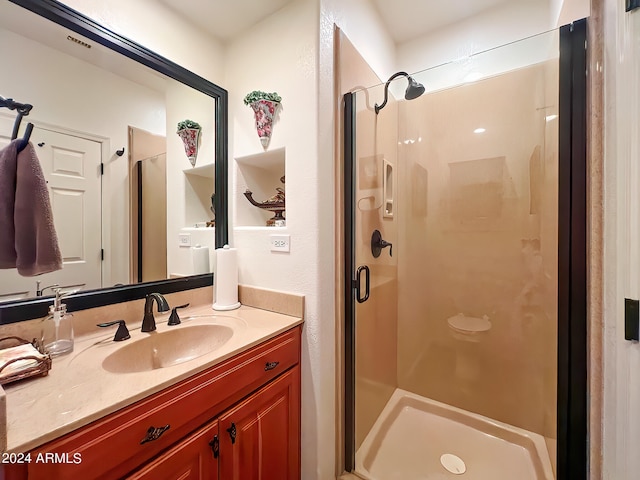 bathroom featuring visible vents, vanity, and a shower stall