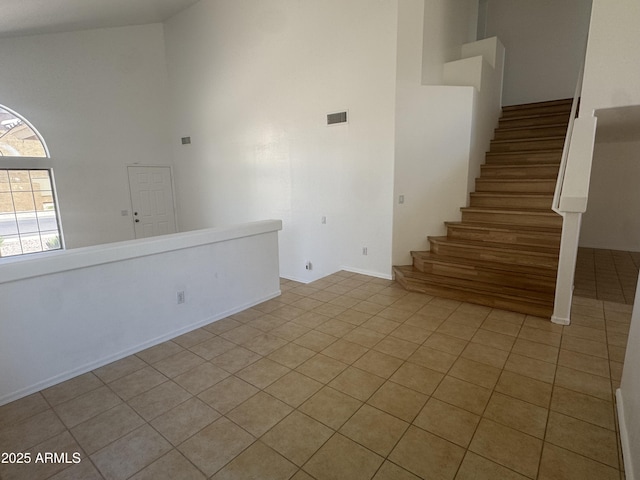 6416 N 78th Ln, Glendale, AZ 85303 - unfurnished living room featuring high vaulted ceiling, light tile patterned floors, and stairs