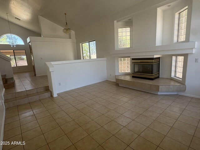 6416 N 78th Ln, Glendale, AZ 85303 - unfurnished living room featuring high vaulted ceiling, tile patterned flooring, a chandelier, healthy amount of natural light, and baseboards