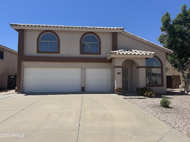 6416 N 78th Ln, Glendale, AZ 85303 - mediterranean / spanish home with an attached garage, concrete driveway, cooling unit, stucco siding, and a tiled roof
