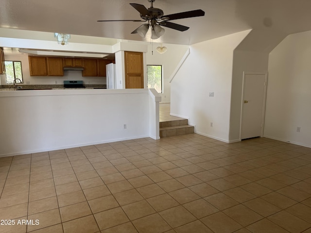 6416 N 78th Ln, Glendale, AZ 85303 - unfurnished living room featuring ceiling fan, plenty of natural light, baseboards, and light tile patterned flooring