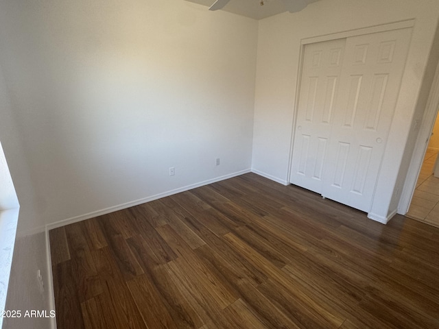 6416 N 78th Ln, Glendale, AZ 85303 - unfurnished bedroom with dark wood-style floors, a closet, and baseboards
