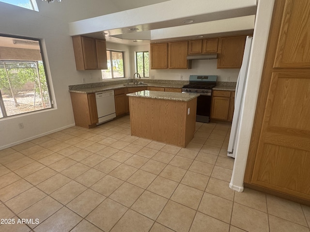 6416 N 78th Ln, Glendale, AZ 85303 - kitchen featuring white appliances, a kitchen island, under cabinet range hood, a sink, and light tile patterned floors
