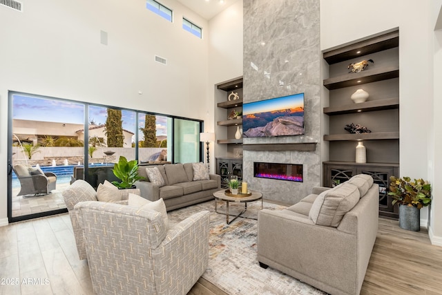 2656 E Oriole Dr, Gilbert, AZ 85297 - living room with built in features, a high end fireplace, and light hardwood / wood-style flooring