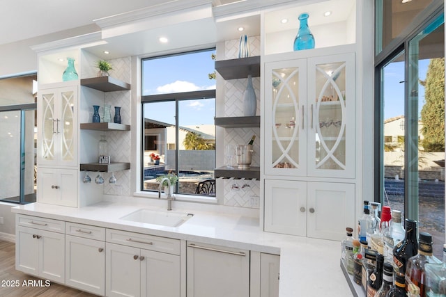 2656 E Oriole Dr, Gilbert, AZ 85297 - interior space with decorative backsplash, sink, white cabinetry, and light hardwood / wood-style floors