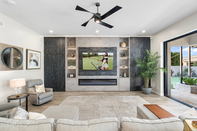 2656 E Oriole Dr, Gilbert, AZ 85297 - living room featuring a fireplace, ceiling fan, built in features, and light hardwood / wood-style flooring