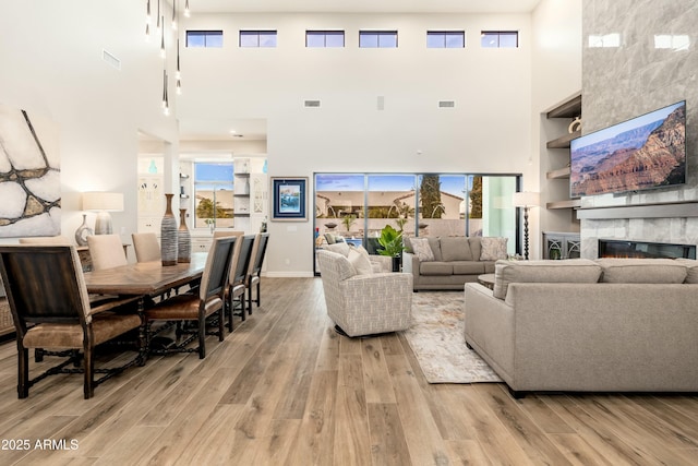 2656 E Oriole Dr, Gilbert, AZ 85297 - living room featuring a fireplace, light wood-type flooring, and a towering ceiling