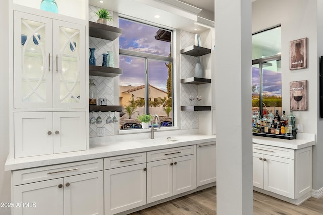 2656 E Oriole Dr, Gilbert, AZ 85297 - bar featuring sink, white cabinets, tasteful backsplash, and light hardwood / wood-style flooring