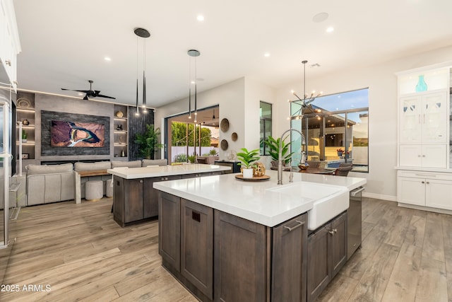 2656 E Oriole Dr, Gilbert, AZ 85297 - kitchen featuring decorative light fixtures, dark brown cabinetry, a kitchen island with sink, and white cabinets