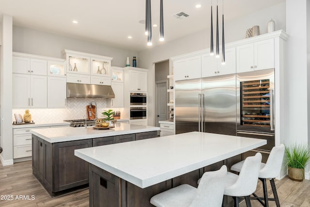 2656 E Oriole Dr, Gilbert, AZ 85297 - kitchen featuring hardwood / wood-style floors, white cabinetry, a kitchen island, decorative light fixtures, and decorative backsplash