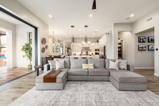 2656 E Oriole Dr, Gilbert, AZ 85297 - living room featuring light wood-type flooring and a notable chandelier