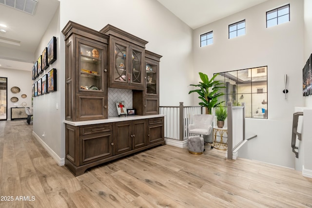 2656 E Oriole Dr, Gilbert, AZ 85297 - interior space with light hardwood / wood-style flooring, tasteful backsplash, dark brown cabinetry, and a high ceiling