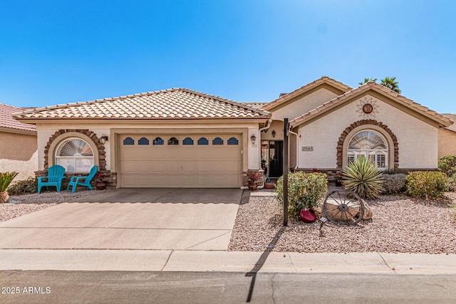 mediterranean / spanish home featuring a tile roof, stucco siding, driveway, and an attached garage