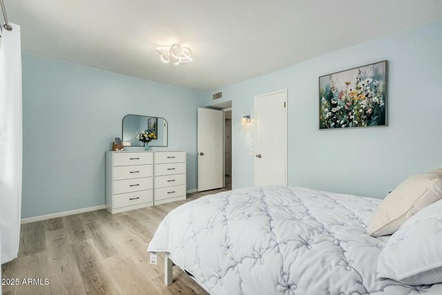 bedroom featuring visible vents, baseboards, and wood finished floors