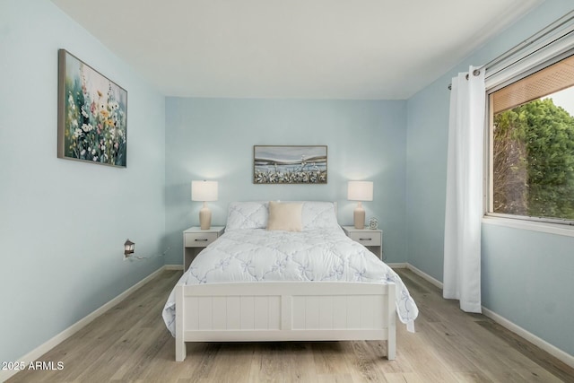 bedroom featuring baseboards and wood finished floors