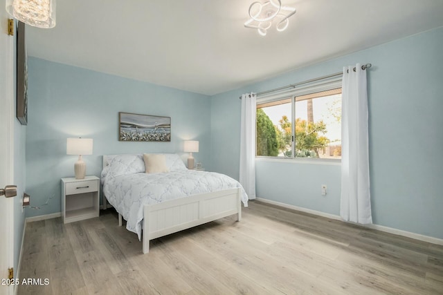 bedroom with baseboards and wood finished floors