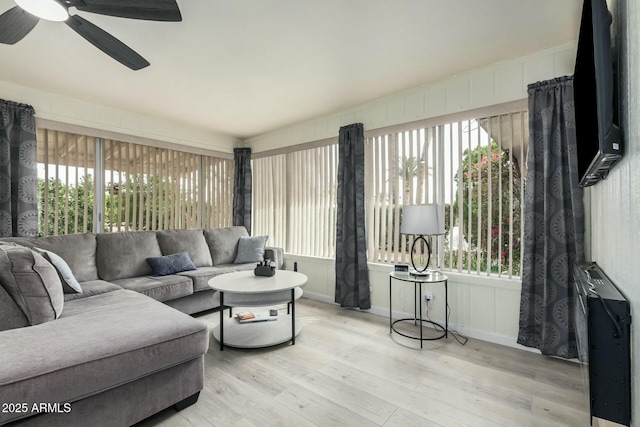 living area with plenty of natural light, a ceiling fan, and wood finished floors