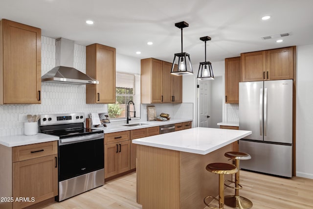 635 N 67th Pl, Mesa, AZ 85205 - kitchen featuring appliances with stainless steel finishes, wall chimney range hood, a sink, light wood-type flooring, and recessed lighting