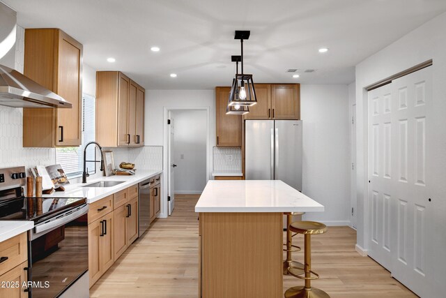 635 N 67th Pl, Mesa, AZ 85205 - kitchen featuring appliances with stainless steel finishes, wall chimney range hood, a sink, light wood-style floors, and a center island