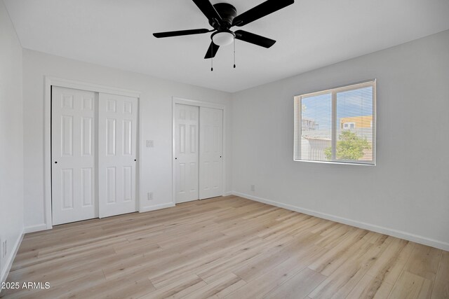 635 N 67th Pl, Mesa, AZ 85205 - unfurnished bedroom with two closets, light wood finished floors, baseboards, and a ceiling fan