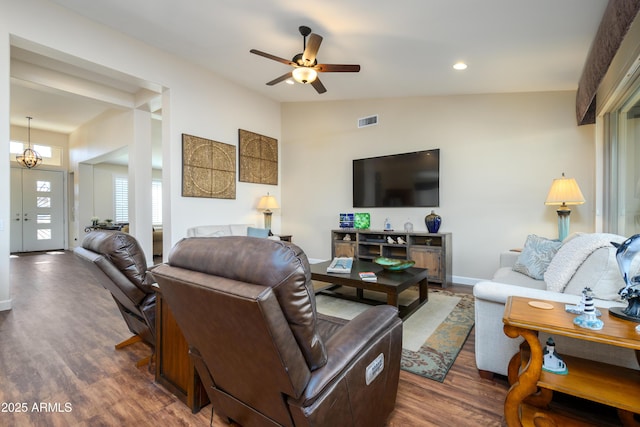 living room with vaulted ceiling, dark hardwood / wood-style floors, and ceiling fan with notable chandelier