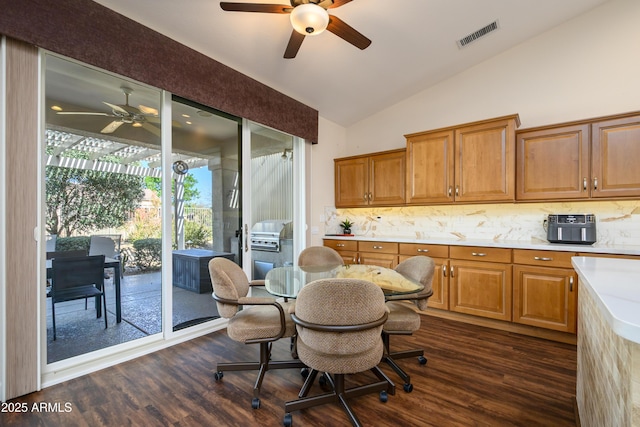 dining space featuring ceiling fan, lofted ceiling, and dark hardwood / wood-style flooring