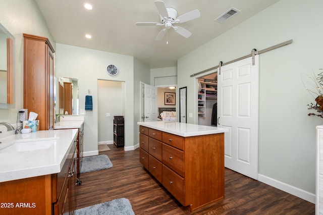 kitchen featuring a barn door, a center island, sink, and dark hardwood / wood-style floors