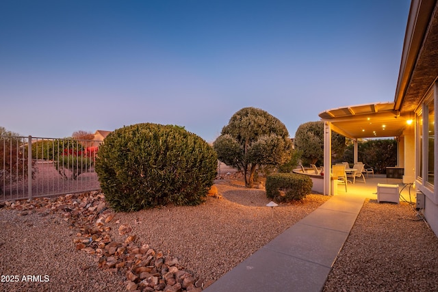 yard at dusk featuring a patio area