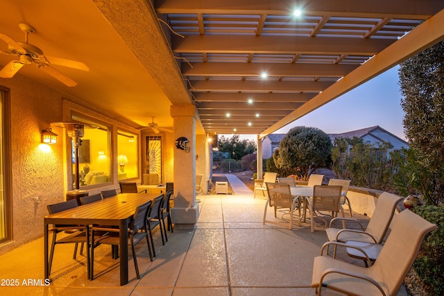 patio terrace at dusk with ceiling fan and a pergola