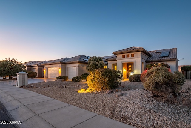 mediterranean / spanish-style home featuring a garage and solar panels