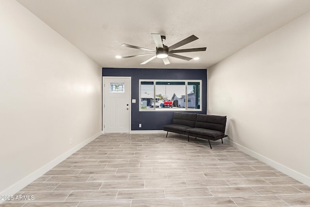 living area with ceiling fan, baseboards, and wood finish floors