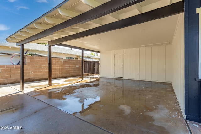 view of patio with a carport and fence