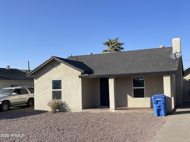 single story home featuring a shingled roof and stucco siding