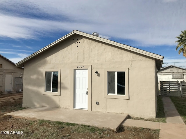 back of house featuring a patio area, fence, and stucco siding