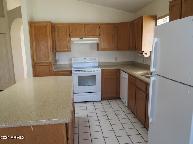 kitchen with light tile patterned flooring, white appliances, light countertops, under cabinet range hood, and vaulted ceiling