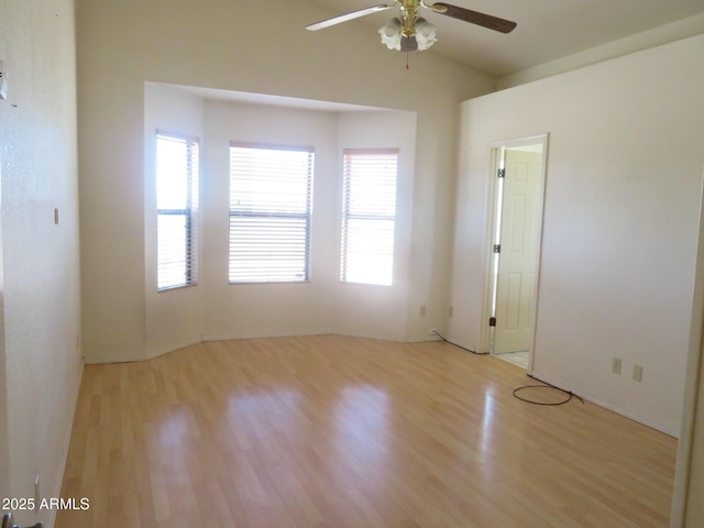 unfurnished room featuring a ceiling fan, wood finished floors, and lofted ceiling
