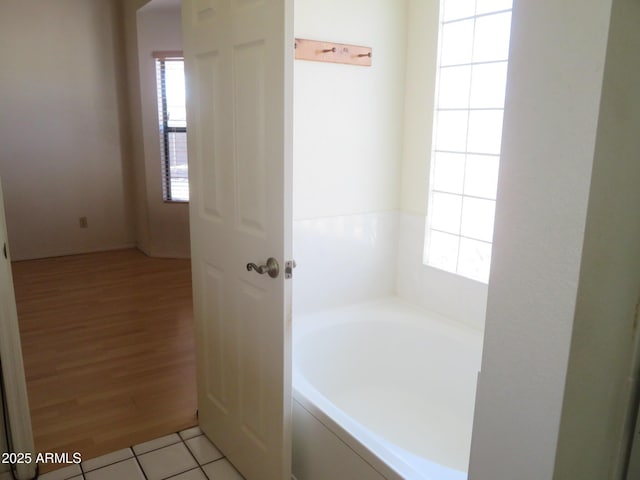 full bathroom with a garden tub and wood finished floors