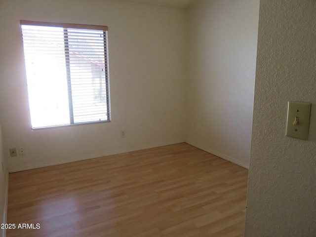 unfurnished room with baseboards and light wood finished floors