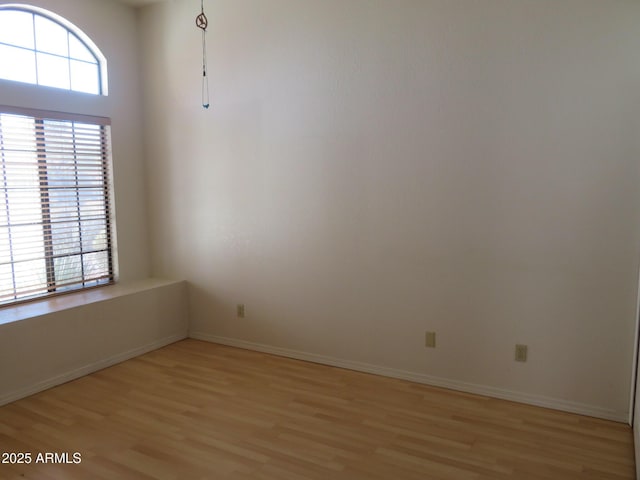 empty room with light wood-type flooring and baseboards