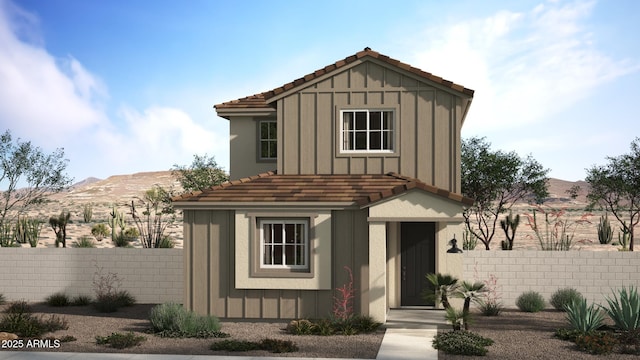 view of front of house with a mountain view, board and batten siding, and a fenced front yard