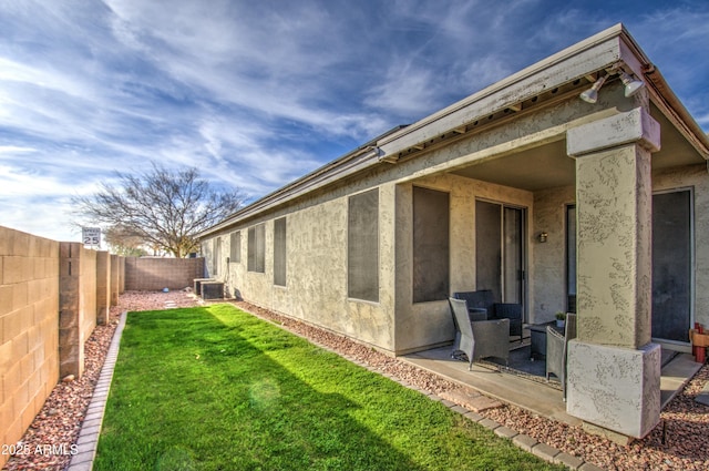 back of property featuring central AC, a lawn, and a patio