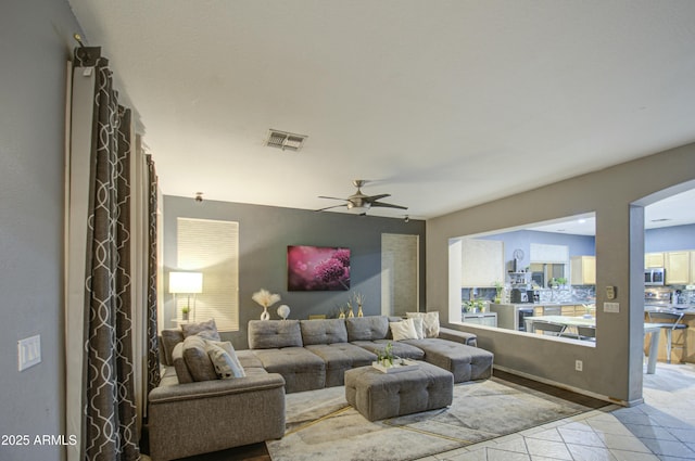 living room featuring light tile patterned floors and ceiling fan